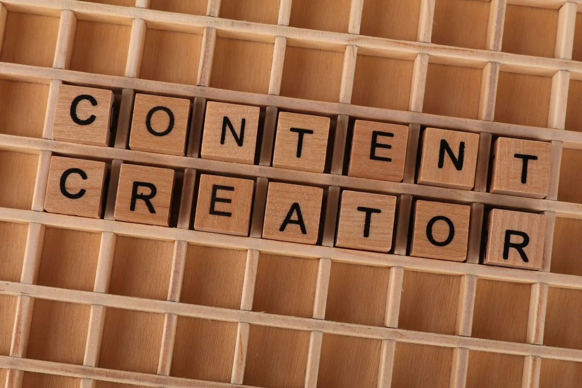 Wooden block letters spelling Content Creator on a grid background