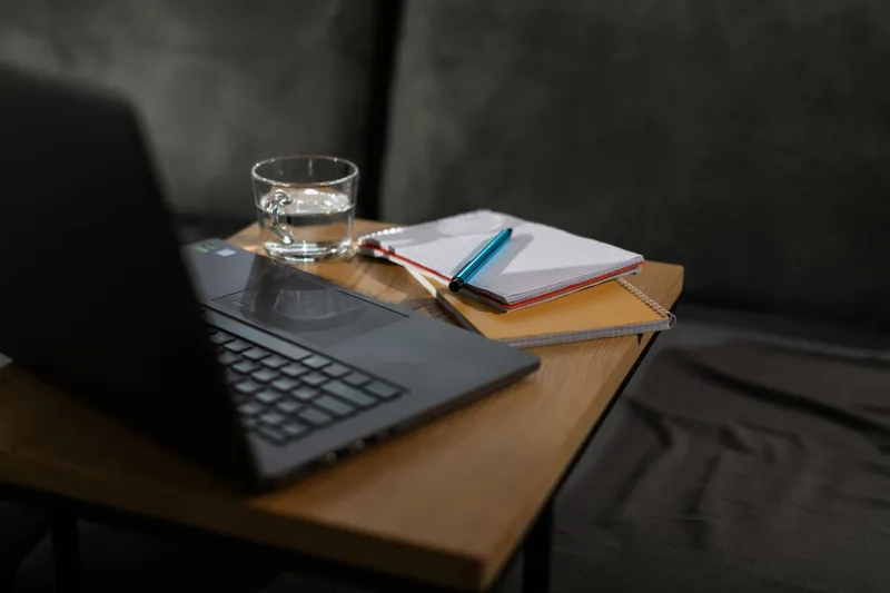 Creative workspace with laptop and notes on wooden desk