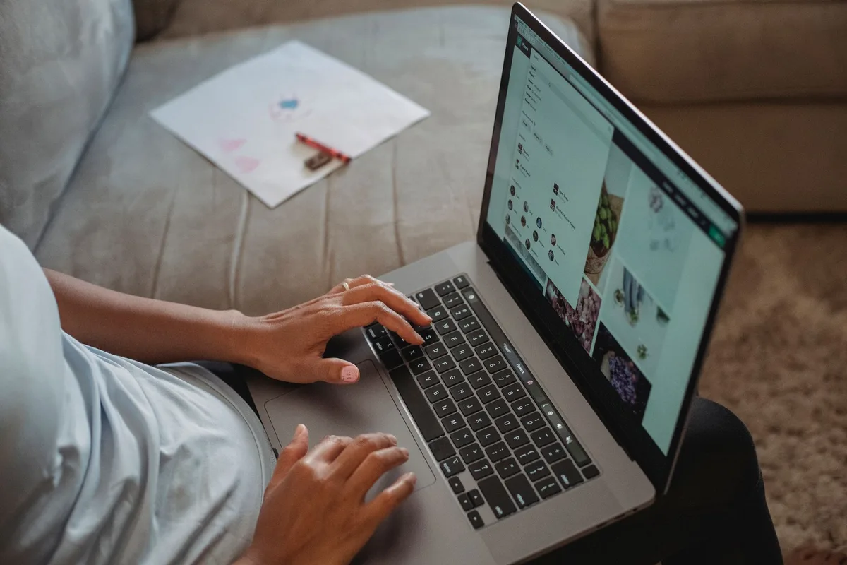 Creator at laptop designing a digital product with Canva open on screen