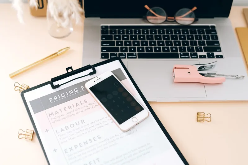 Handwritten pricing notes with calculator for digital product pricing strategy