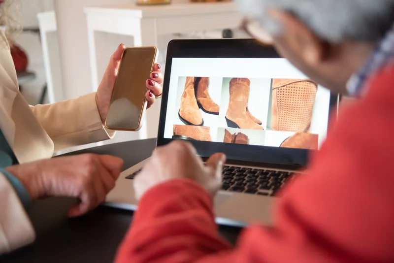 Two people looking at an online storefront on a laptop while shopping