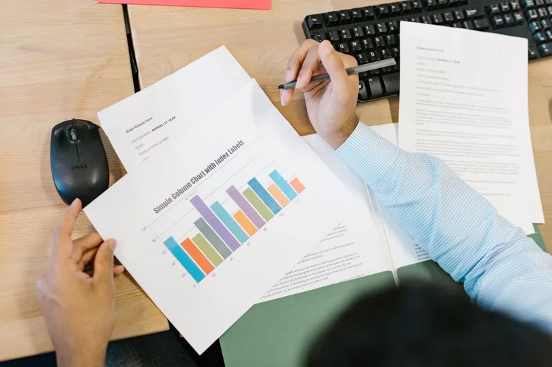 Person reviewing sales performance data on a laptop at a desk, analyzing digital product metrics