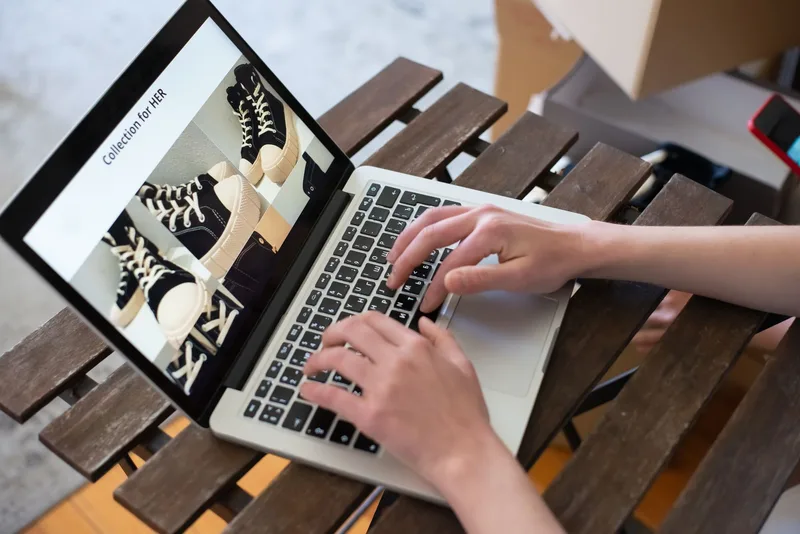 Woman working on laptop setting up an online product listing in a modern e-commerce interface
