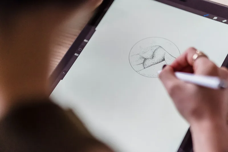 An artist working at a computer creating digital artwork