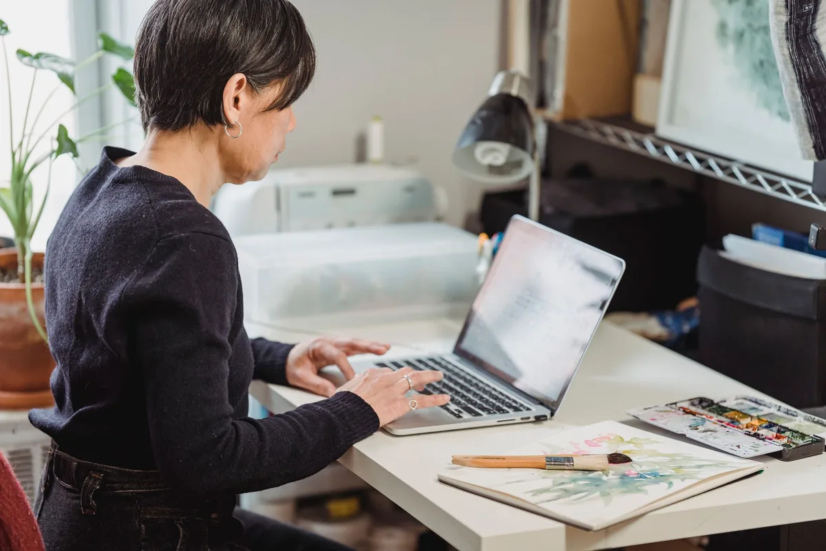Artist creating digital artwork at a desk with a drawing tablet