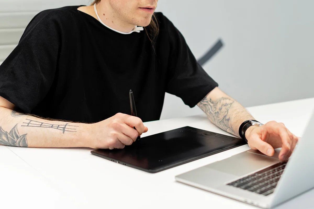 Artist creating digital art on a drawing tablet at a creative workspace