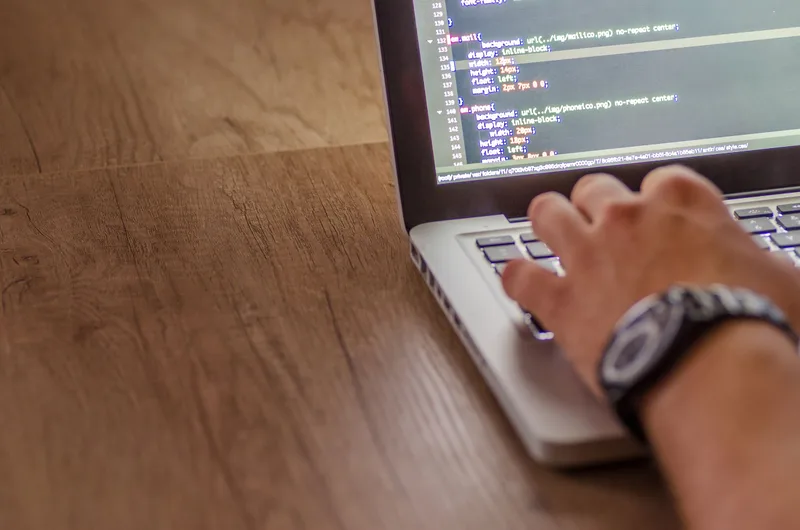 Close-up of a person coding on a laptop