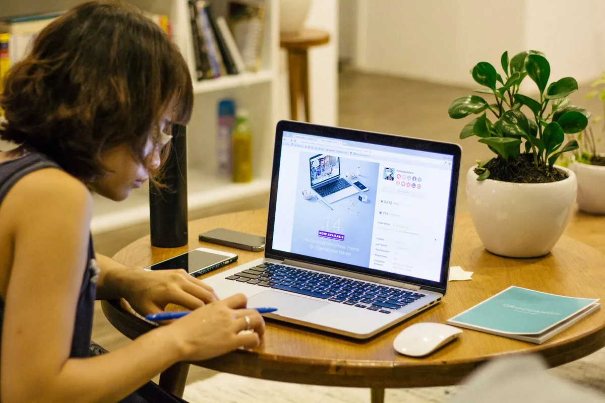 Creator working on digital products at a laptop setup